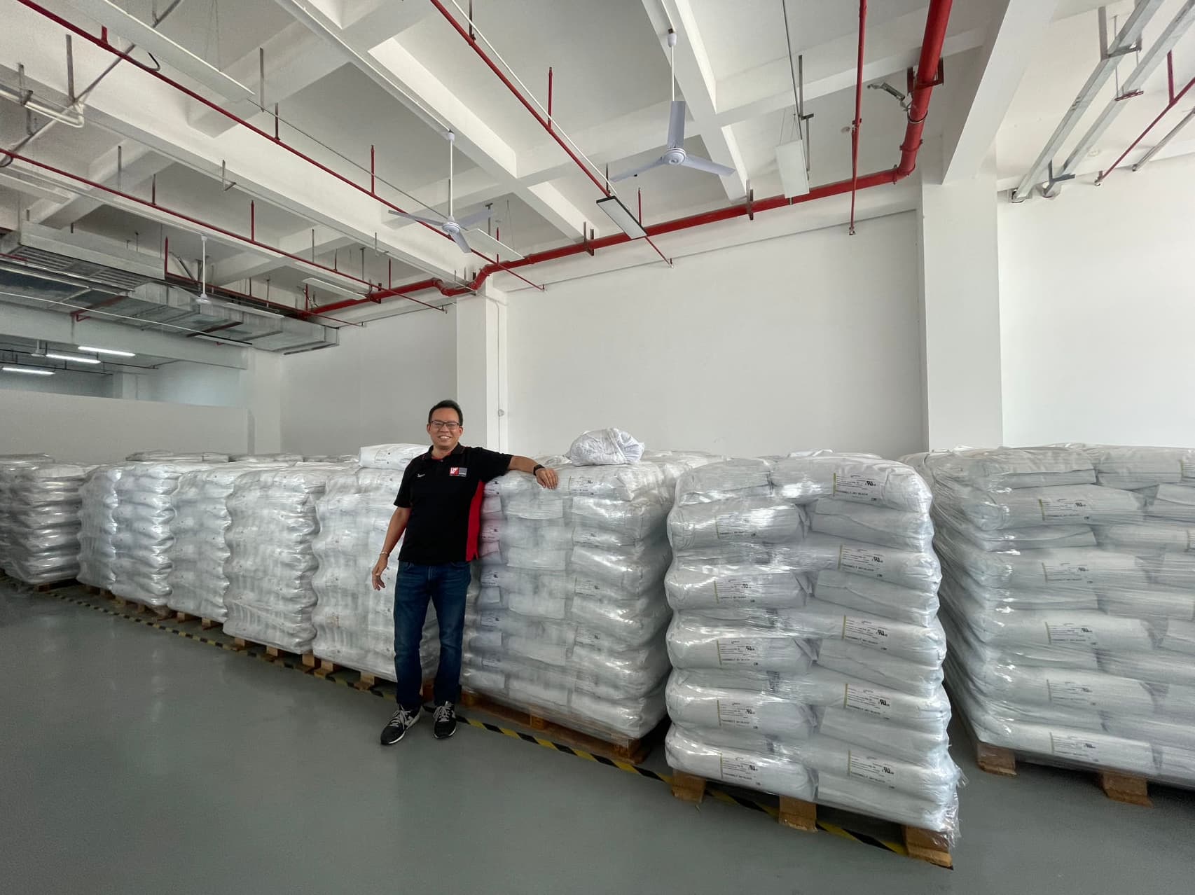 Mr. Jason Xi standing in front of their adhesive